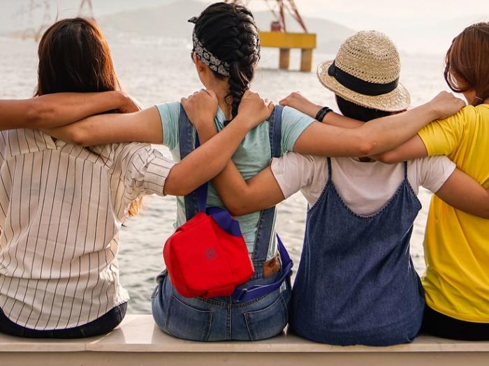 Friends with arms around each others back